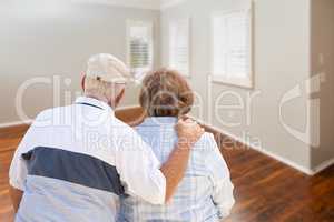 Senior Couple Facing Empty Room of New House