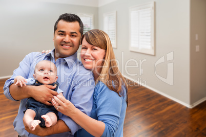 Young Couple With Baby In Empty Room of New House