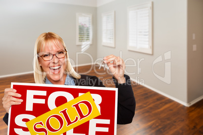 Woman with Sold For Sale Real Estate Sign and Keys In Empty Room