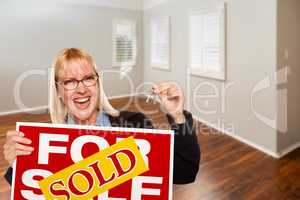 Woman with Sold For Sale Real Estate Sign and Keys In Empty Room
