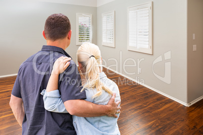 Young Couple Facing Empty Room of New House