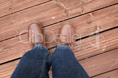Feet in red shoes on a red wood floor