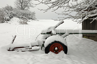 Agricultural machinery on a farm covered with snow