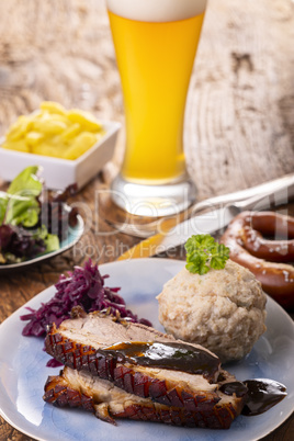 Schweinebraten auf einem blauen Teller