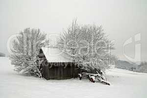 Agricultural machinery on a farm covered with snow