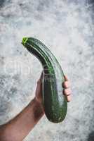 Hand holding zucchini