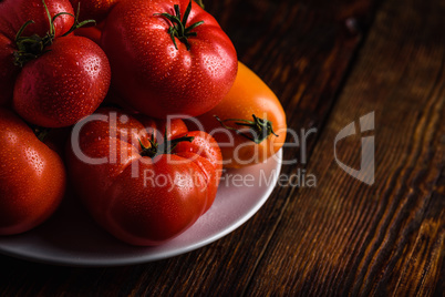 Fresh red and yellow tomatoes on plate