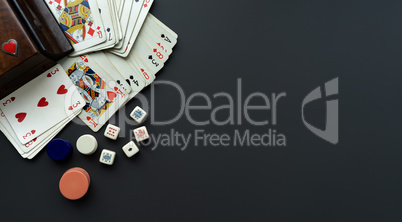 Playing cards and dice on a dark grey background.