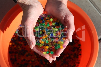 Small colorful plastic balls in the hands