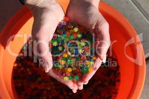 Small colorful plastic balls in the hands