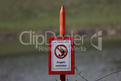 Sign by the lake in spring. Text in German: Fishing forbidden