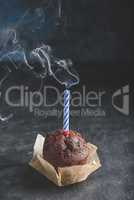 Birthday chocolate muffin with smoking candle