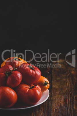 Fresh red and yellow tomatoes on plate