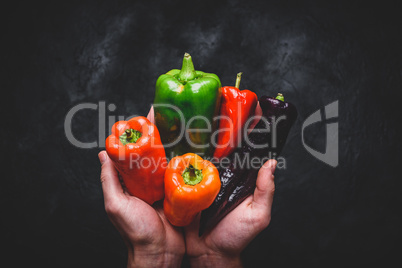 Hands with different bell peppers