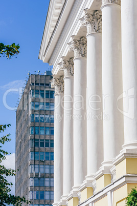 Front of Buildig with Columns and Skyscrapper on Background.