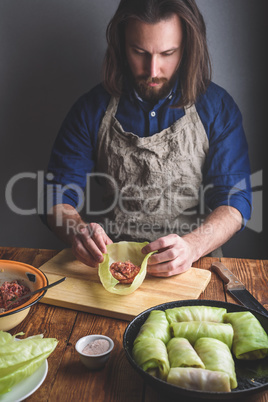 Man Cooking Cabbage Rolls Stuffed with Ground Meat