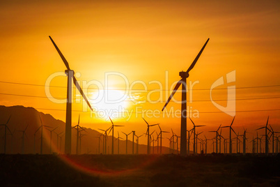Sun Setting Over Electircal Power Lines and Wind Turbine Farm Si