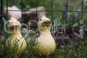 Decorative ducklings among the plants in the garden