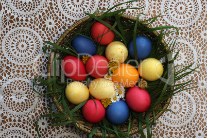 Colorful Easter eggs in a basket made up with flowers