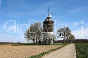 Spring landscape with water tower by the road