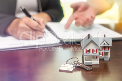 Real estate agent and customer sign contract papers with house k