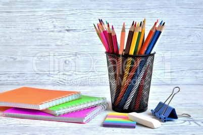 Color pads and colored pencils in a container, eraser and paper