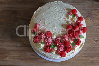 Birthday cake with cream and fresh raspberries