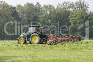 Shaking of freshly cut grass with tractor and tedder.