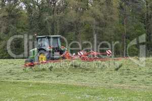 Shaking of freshly cut grass with tractor and tedder.