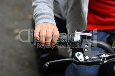 Childs hand on the steering wheel of a quad
