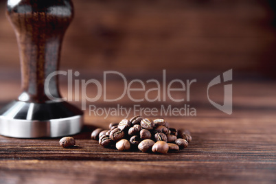 temper coffee beans on a brown wooden background blur
