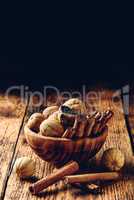 Cinnamon sticks and dried limes in wooden bowl