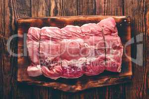 Pork loin joint on rustic cutting board