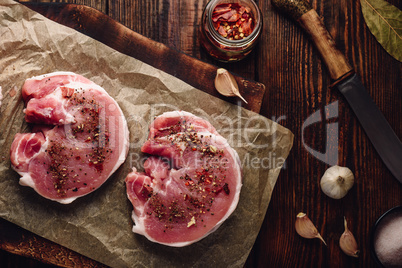 Raw pork loin steaks with different spices