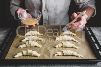 Baking sheet of raw croissants stuffed with chocolate spread