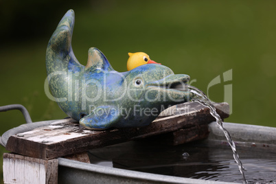 Decorative fountain in the garden in the form of a dolphin