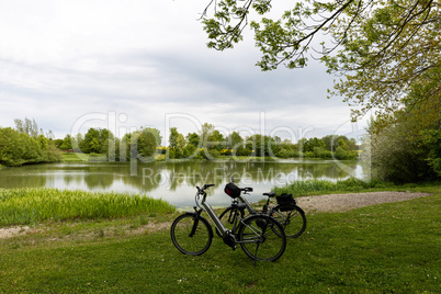Bicycles stand on the shore of a small lake