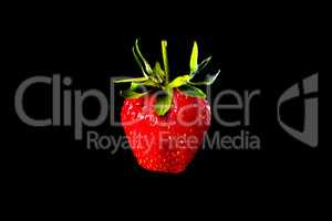 Strawberries on a black background with green leaves background