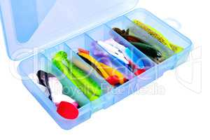Box for fishing accessories with silicone baits inside on a whit