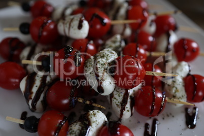 Appetizer with tomatoes, cheese and olives on wooden skewers