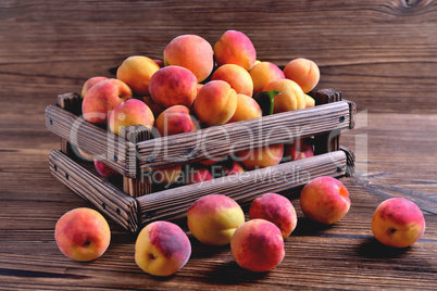 Natural ripe fresh apricots in a wooden crate on a natural woode