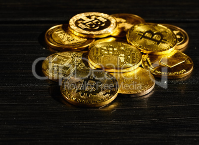 Closeup golden coin with bitcoin logo. Leader in cryptocurrency Bitcoin BTC on a top of coins against black wooden surface. Pile of decentralized digital currency. Crypto payment. Electronic money.