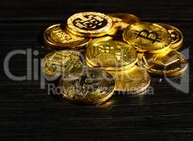 Closeup golden coin with bitcoin logo. Leader in cryptocurrency Bitcoin BTC on a top of coins against black wooden surface. Pile of decentralized digital currency. Crypto payment. Electronic money.