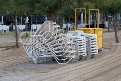 Sandy beach with folded sun loungers in the morning