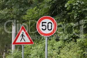 Round speed limit road sign on the road. 50 km per hour