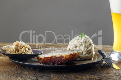 bayerischer Schweinebraten auf dunklem Holz