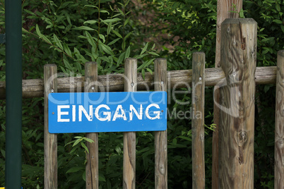 Sign on a wooden fence in German - Entrance