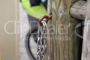 Metal chain hanging from a fence post