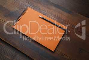 Orange notepad, pencil