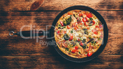 Frittata with broccoli and red pepper in cast iron skillet